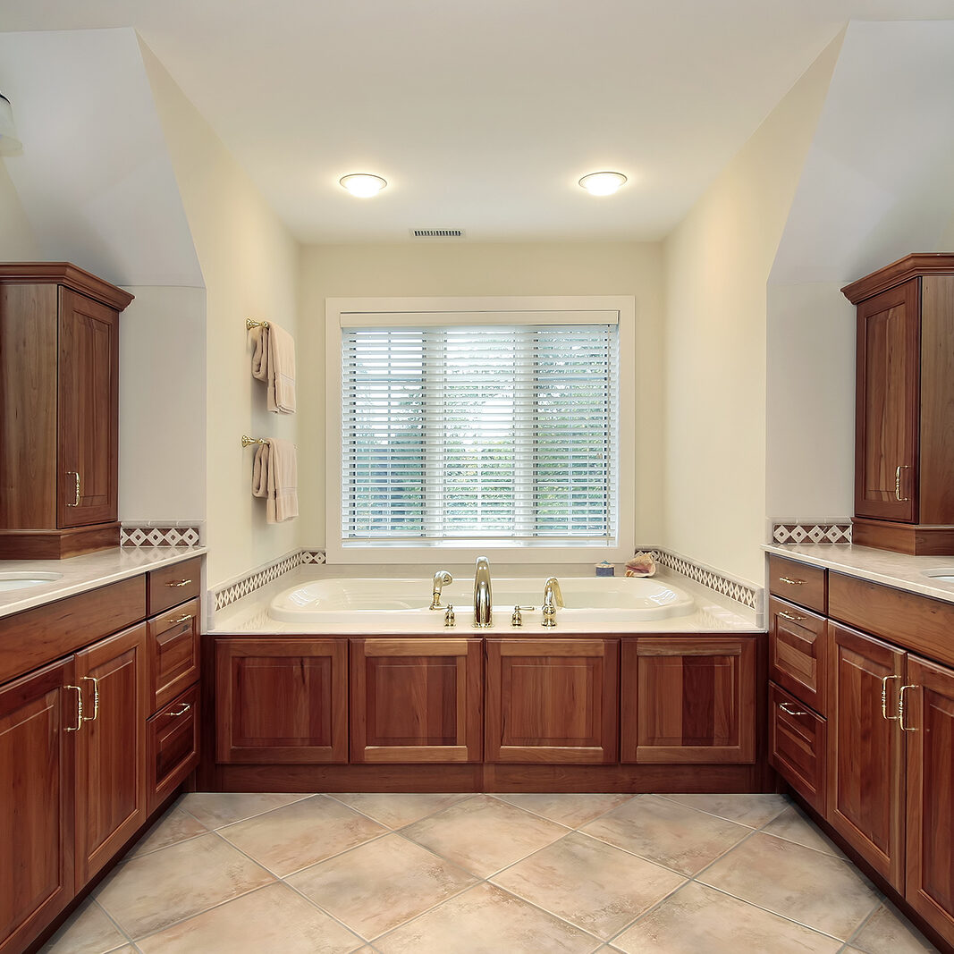 Master bath in luxury home with wood cabinetry